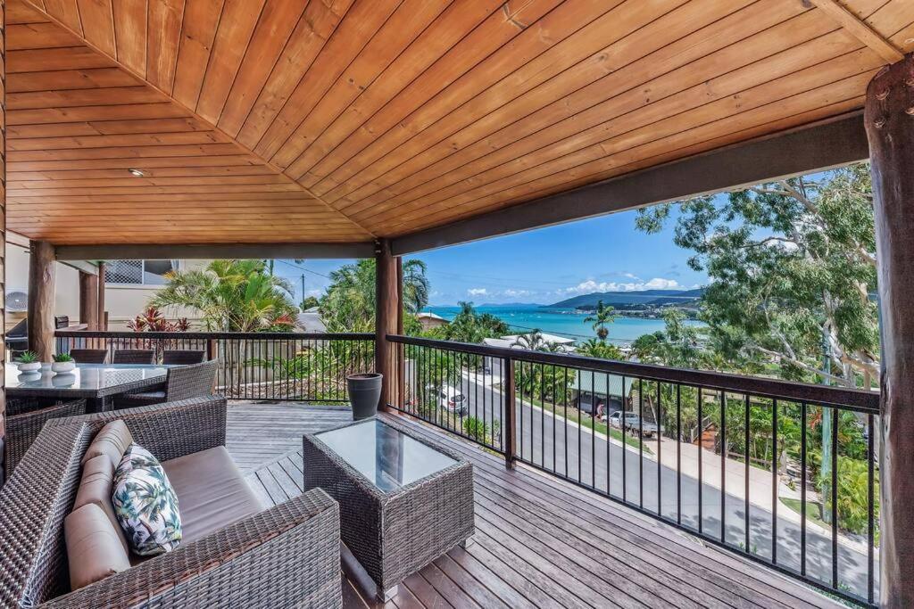 an outdoor deck with furniture and a view of the ocean at Seascape Paradise in Airlie Beach