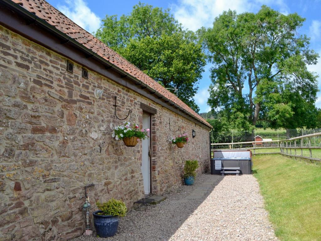 a stone house with a garden and a courtyard at Court Park Barn in Tidenham