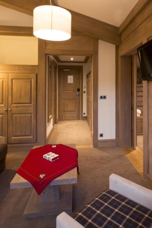 a living room with a red blanket on a table at Hotel le Petit Dru in Morzine