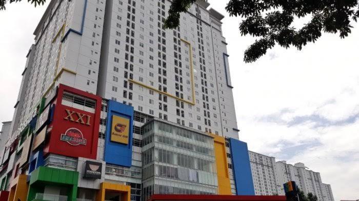 um grande edifício alto com muitas janelas em Bassura City Apartment by Sang Living em Jakarta
