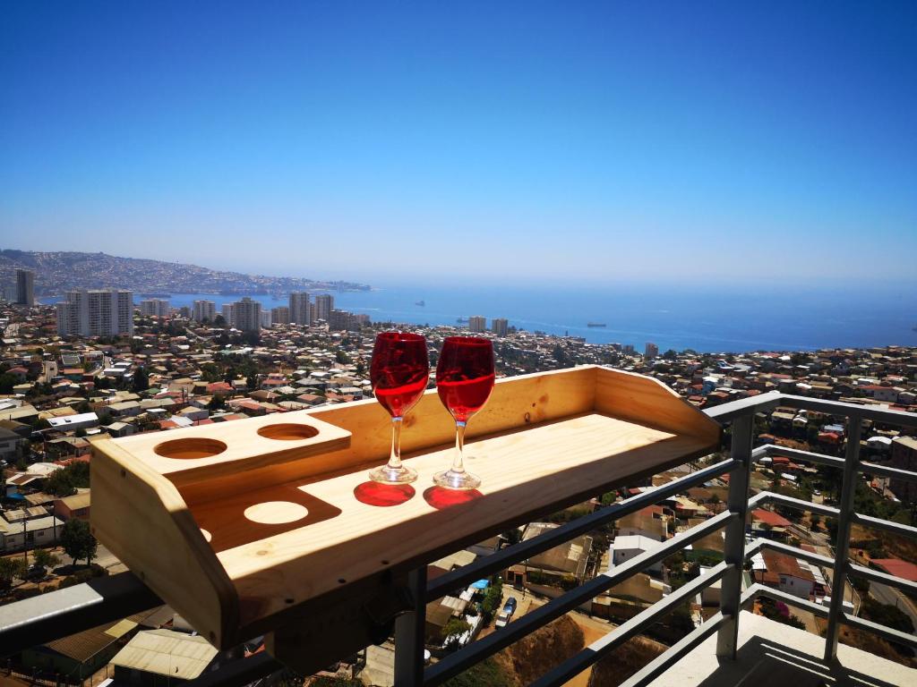 2 bicchieri di vino seduti sopra un balcone di Depto Valparaíso con Vista al Mar y a la Bahía de Valparaíso a Viña del Mar