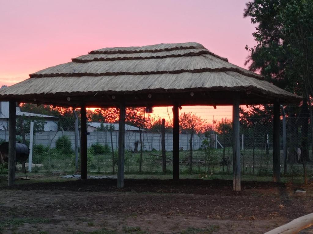 um gazebo de bambu com um pôr-do-sol ao fundo em Quinta Luna Morada em General Rodríguez
