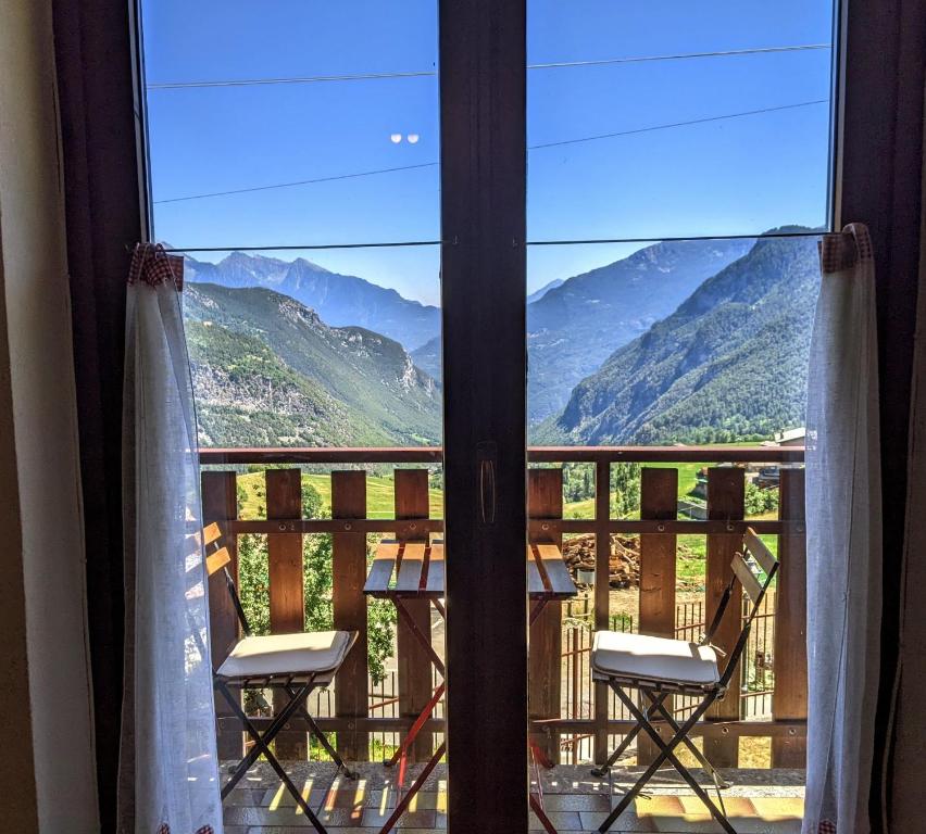 d'un balcon avec deux chaises et une table. dans l'établissement Lovely 4 bedroom villa with amazing views!, à Torgnon
