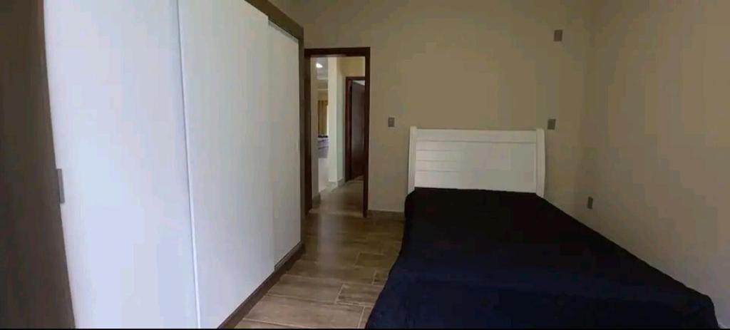 um quarto com uma cama e uma parede branca em Casa Nova em Ouro Preto e Mariana em Ouro Preto
