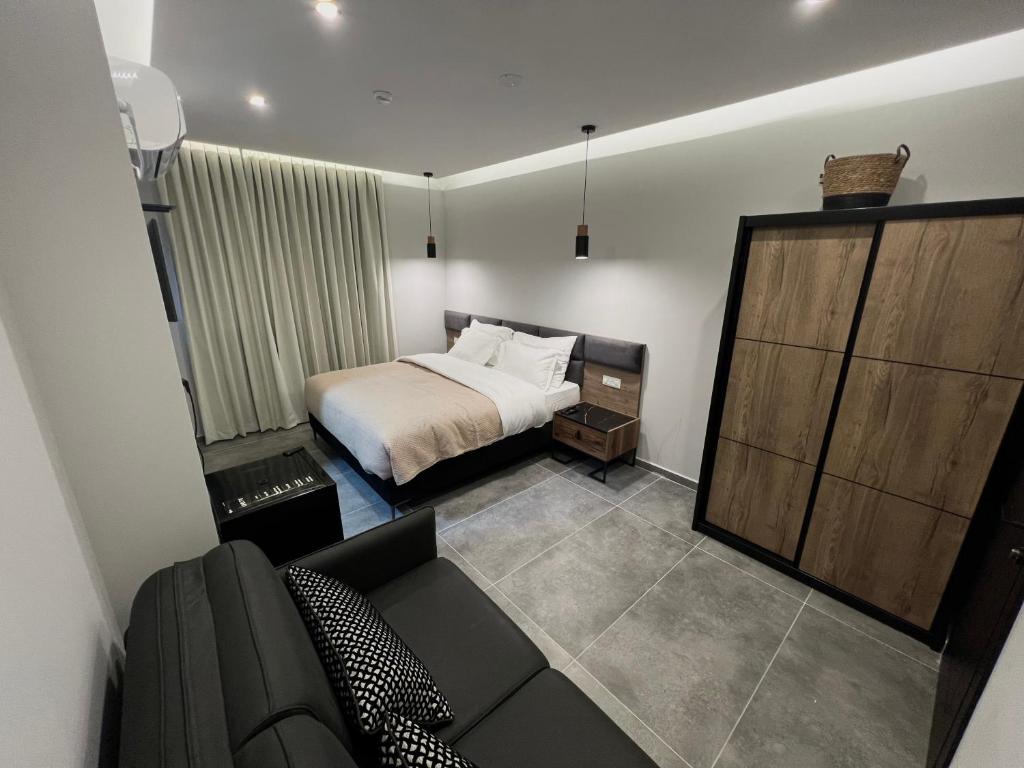 ein Schlafzimmer mit einem Bett und einem Sofa in einem Zimmer in der Unterkunft בוטיק רפאל Boutique Rafael in Eilat