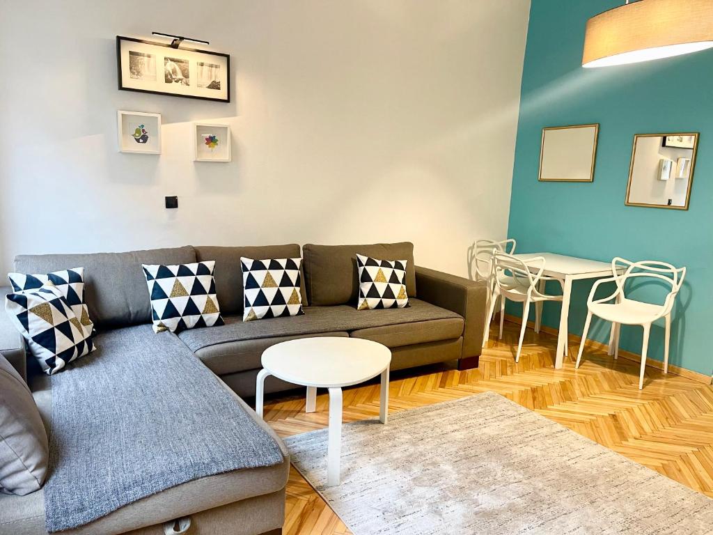 uma sala de estar com um sofá, uma mesa e cadeiras em Apartment Saraj-Bosna Free public Parking em Sarajevo