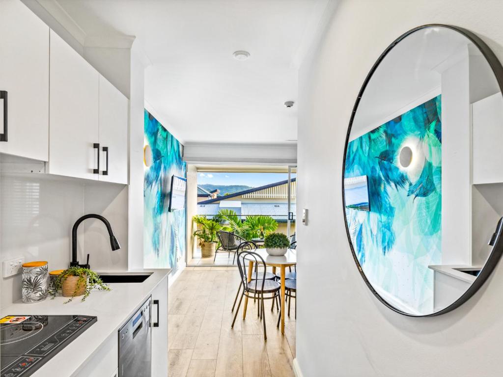 a kitchen with a round mirror on the wall at urban oasis in the heart of town in Port Douglas