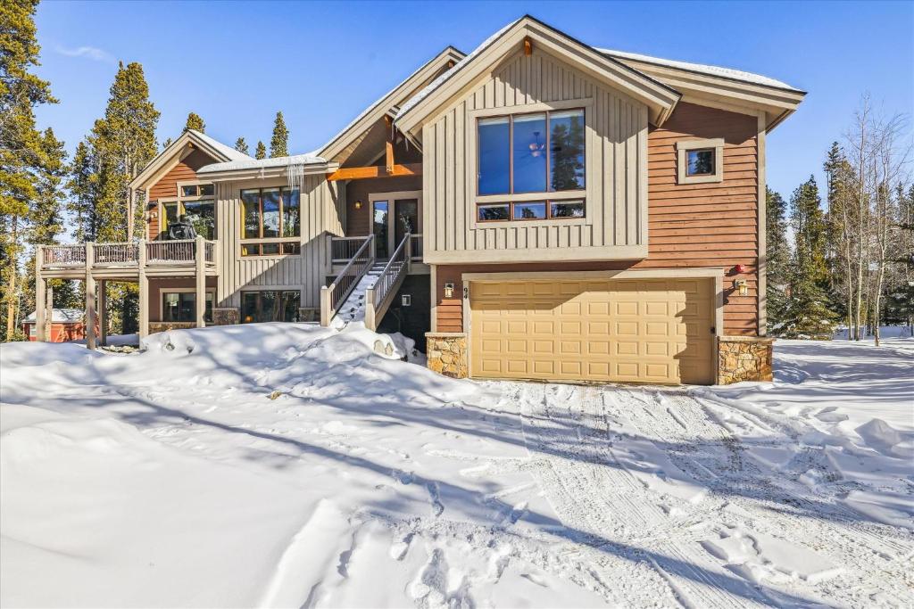 a house in the snow with a driveway at Lone Hand Lodge in Breckenridge