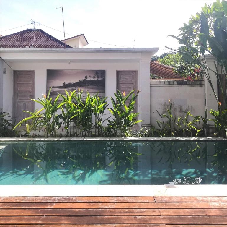 a swimming pool in front of a house at The Joglo Kedungu, Traditional Teakwood in Tanah Lot