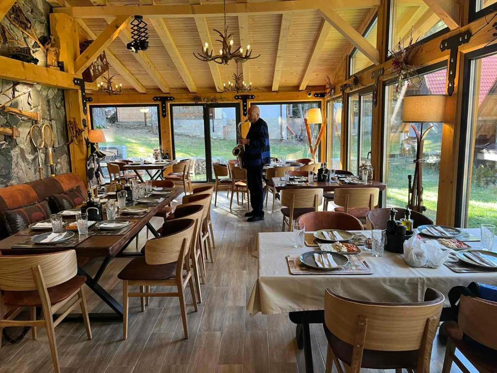 a person standing in a restaurant with tables and chairs at Algara hut in Panichishte