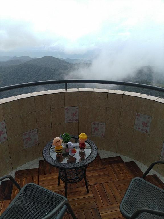 una mesa en un balcón con vistas a las montañas en CloudView Snoopy Theme, Amber Court, Genting Highlands, 1km from Centre, Free Wi-Fi, en Genting Highlands