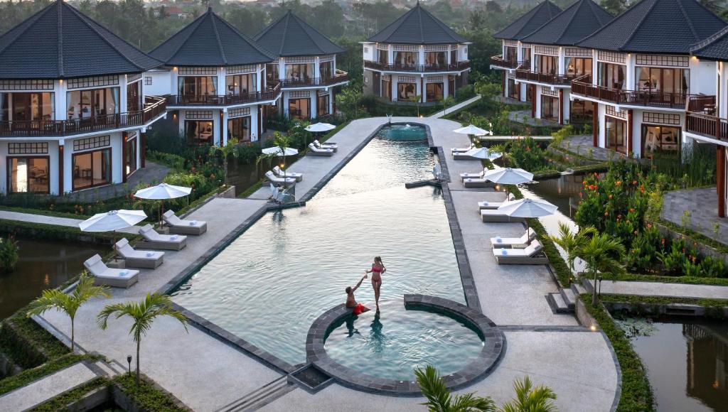 een luchtzicht op een zwembad van het resort met villa's bij Swan Paradise A Pramana Experience in Gianyar