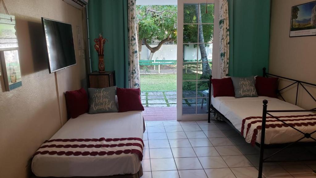 - 2 lits dans une chambre avec fenêtre dans l'établissement ROSI Ocean Sand Hotel Apt (@Sandcastles), à Ocho Rios