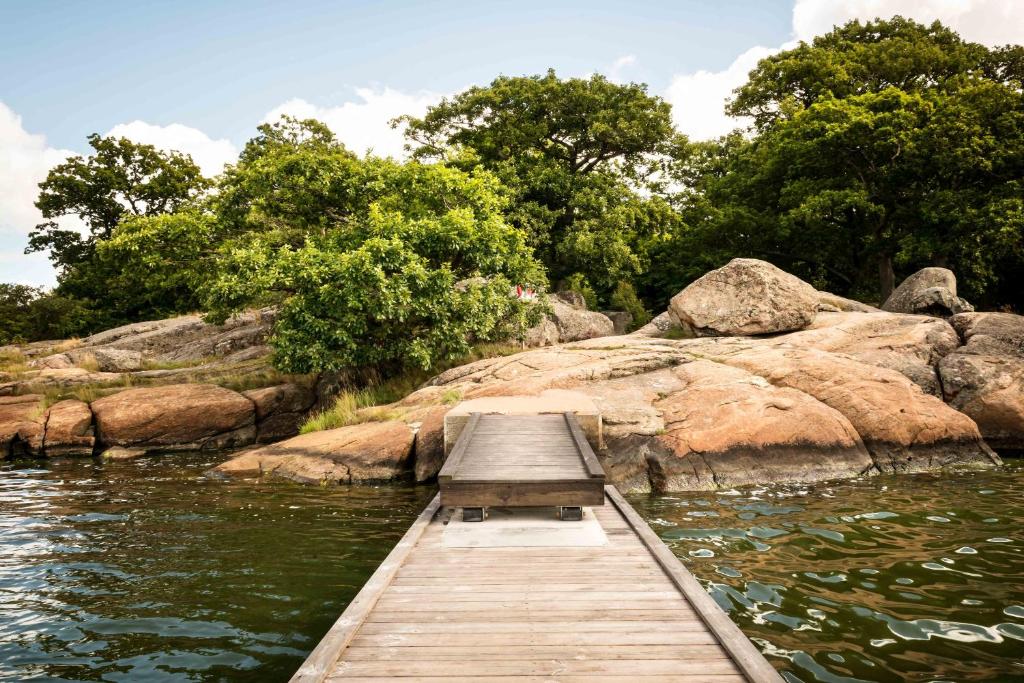 un puente de madera sobre un cuerpo de agua en First Camp Skönstavik Karlskrona en Karlskrona