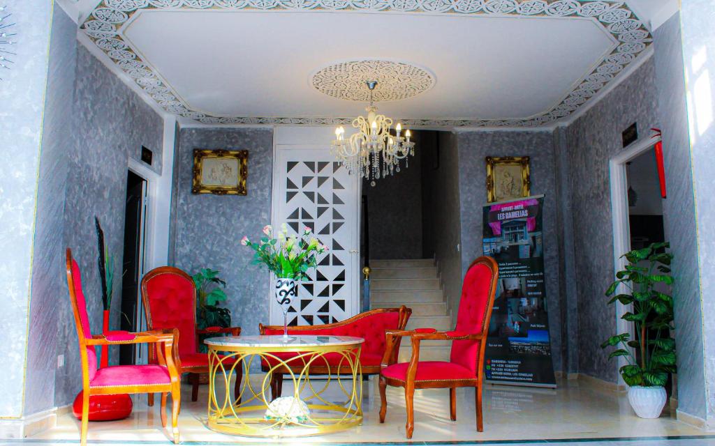 a dining room with red chairs and a table at Résidence Les Camélias in Tabarka