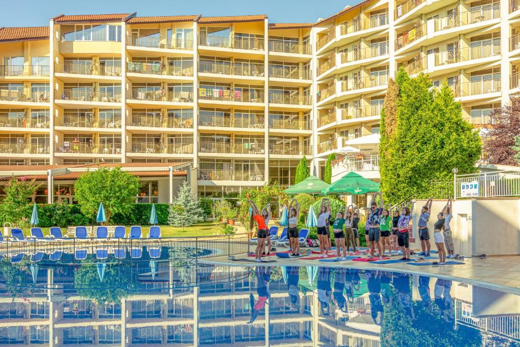 un grupo de personas de pie frente a una piscina en Madara Park Hotel - All Inclusive, en Golden Sands