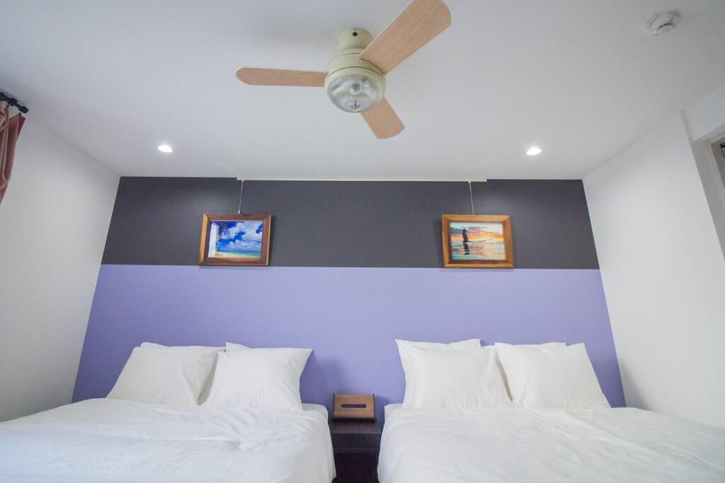 D2HOTEL في أوساكا: غرفة نوم بسريرين ومروحة سقف