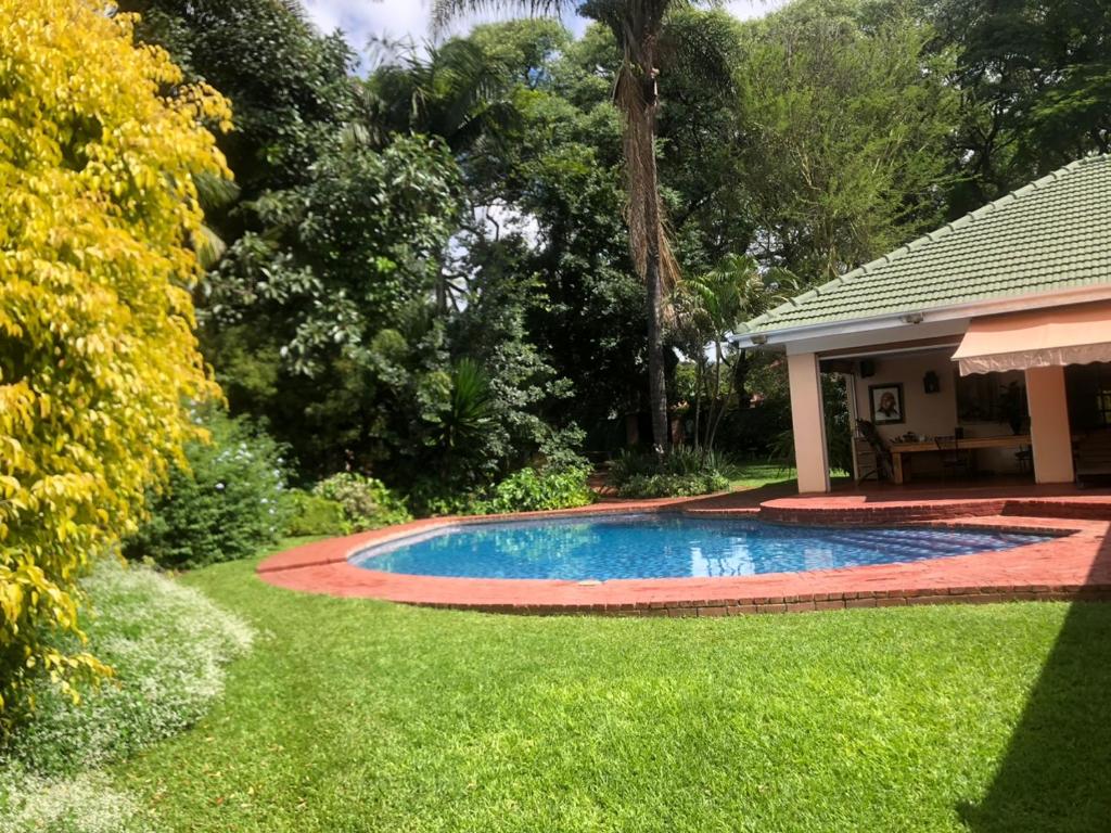 a swimming pool in the yard of a house at African feel studio with kitchenette - 2045 in Harare
