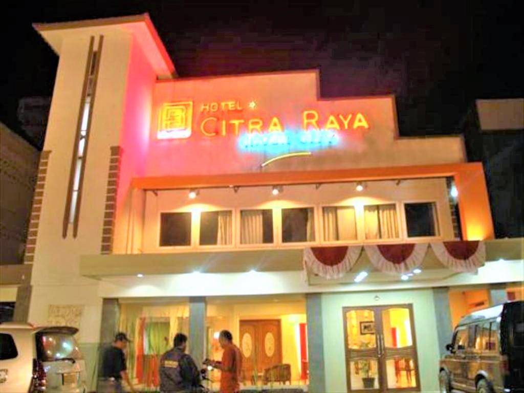 a building with people standing outside of it at night at Citra Raya Hotel Banjarmasin in Banjarmasin