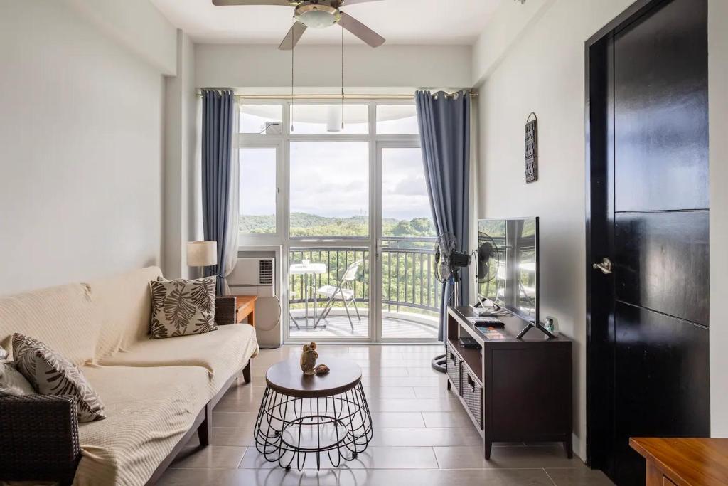 a living room with a couch and a large window at QUIET HOME with private beach in Boracay