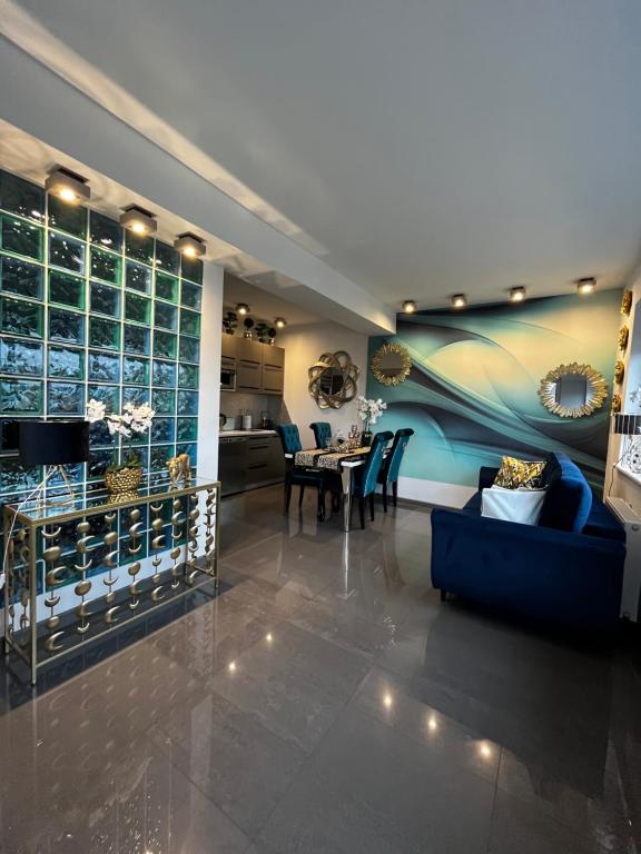 salon z niebieską kanapą i stołem w obiekcie Apartament 308 w Świnoujściu