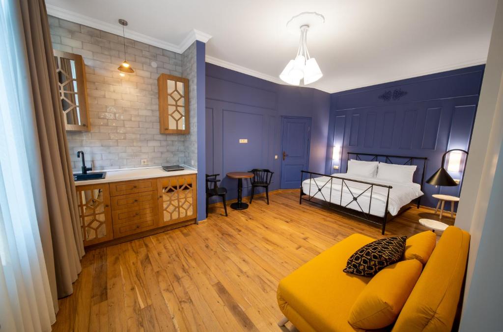 a living room with a yellow couch and a bedroom at Artisan Boutique Hotel & Gallery in Tbilisi City