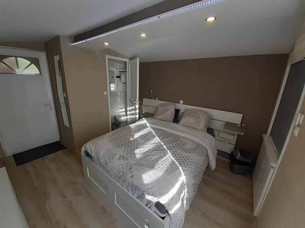 にあるLa cabane à caillouのベッドルーム(白いベッド1台、鏡付)