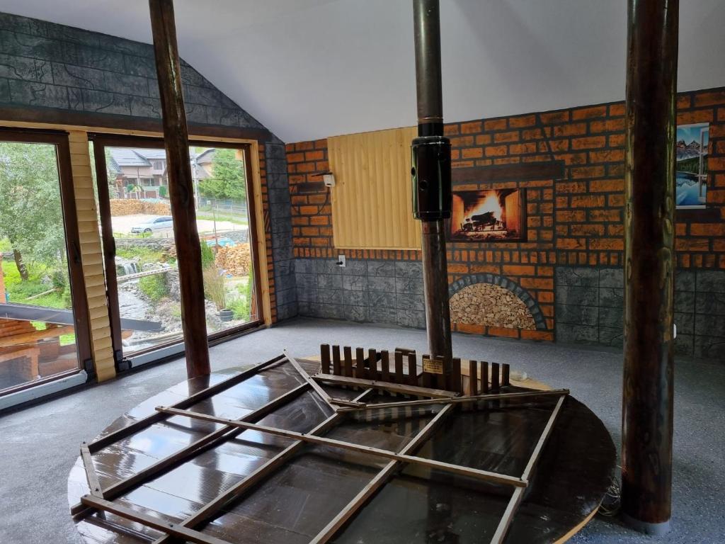 Habitación con mesa de cristal y chimenea. en Zumzetul Raului, en Rucăr