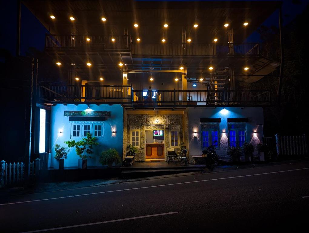 une maison avec des lumières bleues sur une rue la nuit dans l'établissement Hotel Change Badulla, à Badulla