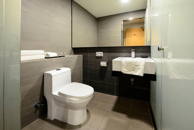 a bathroom with a white toilet and a sink at Beacon Hotel in Taichung