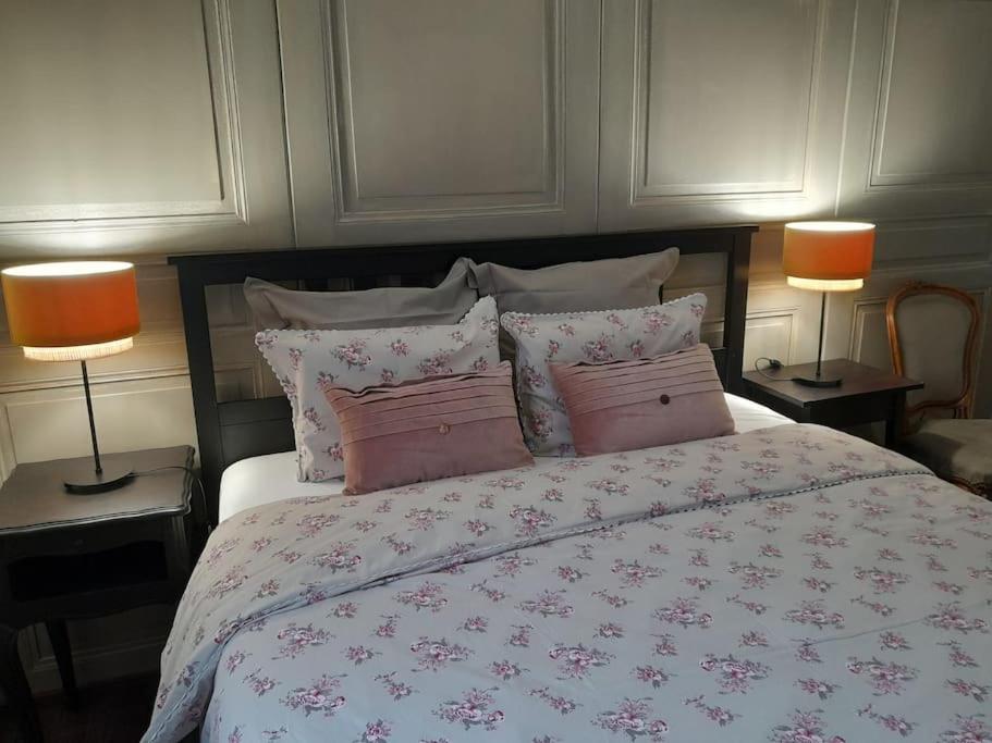 a bedroom with a bed with pink pillows and two lamps at La Mirabelle Gîte de charme in Mackenheim