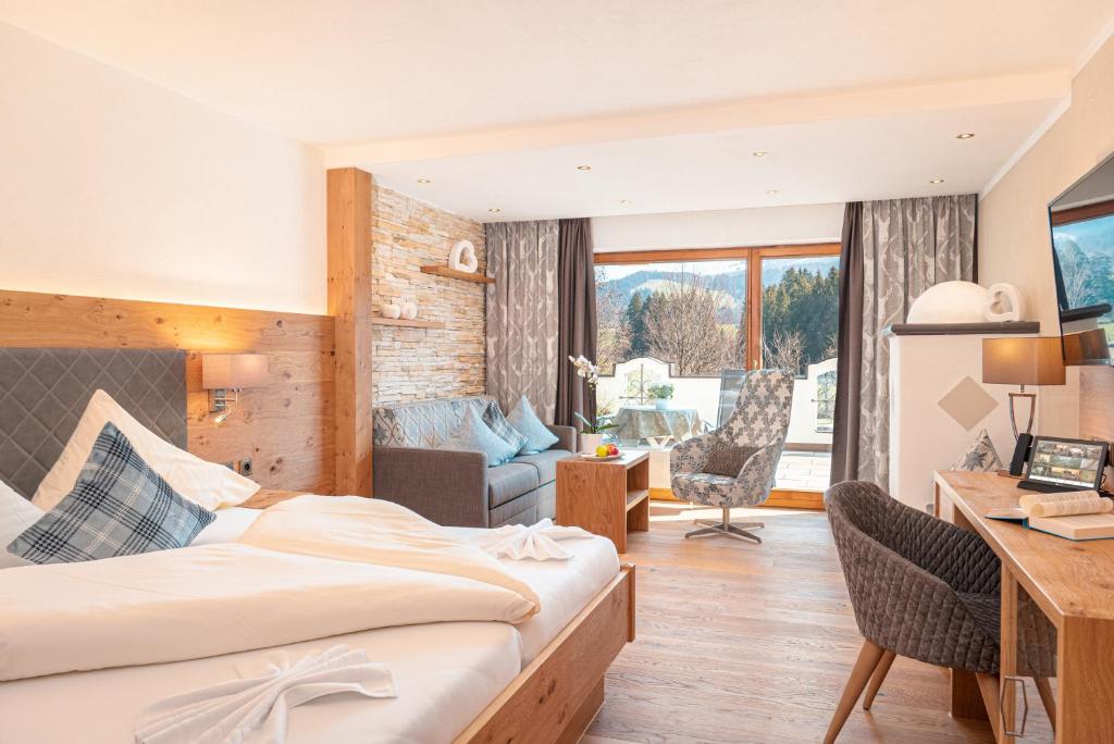 um quarto de hotel com uma cama e uma secretária em Parkhotel Burgmühle em Fischen