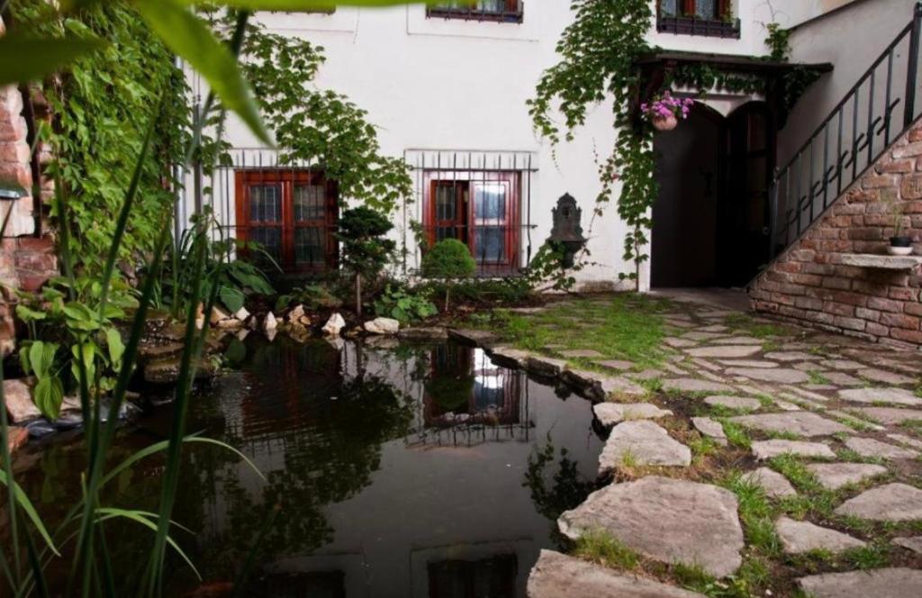 a garden with a pond in front of a building at VIP MiKU apartman 1 in Mikulov