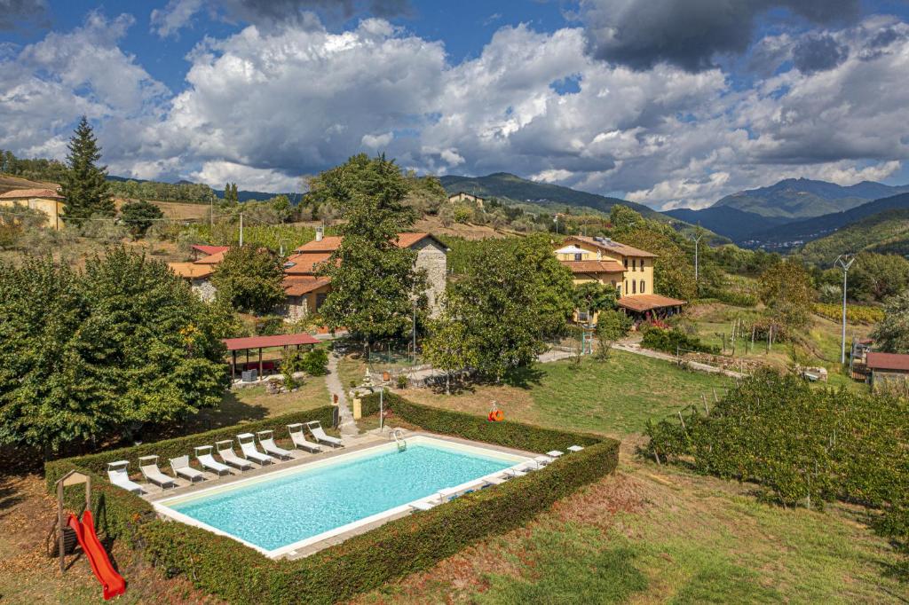 an overhead view of a swimming pool with chairs and a house at Agriturismo Il Bardellino in Fivizzano