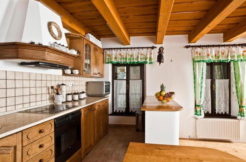 uma cozinha com armários de madeira e cortinas verdes em VIP MiKU apartman 2 em Mikulov