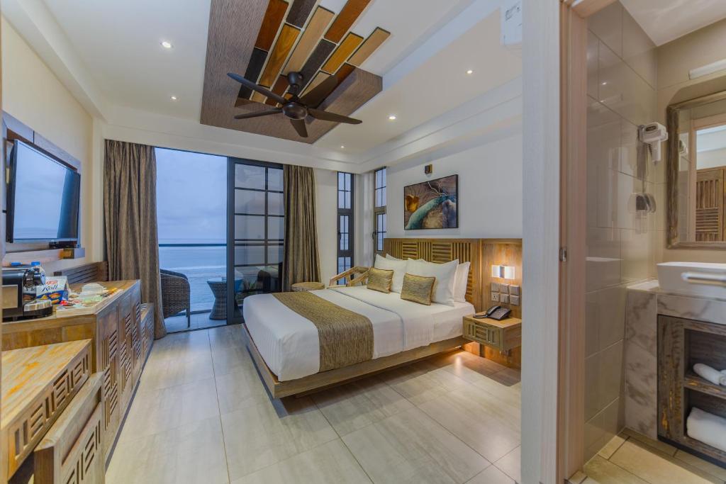 فندق أوشن غراند آت هولهومالي في هولهومالي: غرفة فندقية بها سرير وموقد