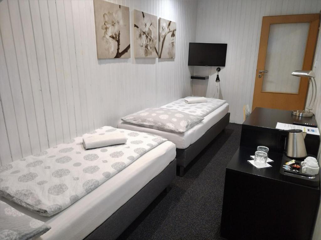 pokój hotelowy z 2 łóżkami i stołem w obiekcie Hotel Boršičanka w Hawierzowie