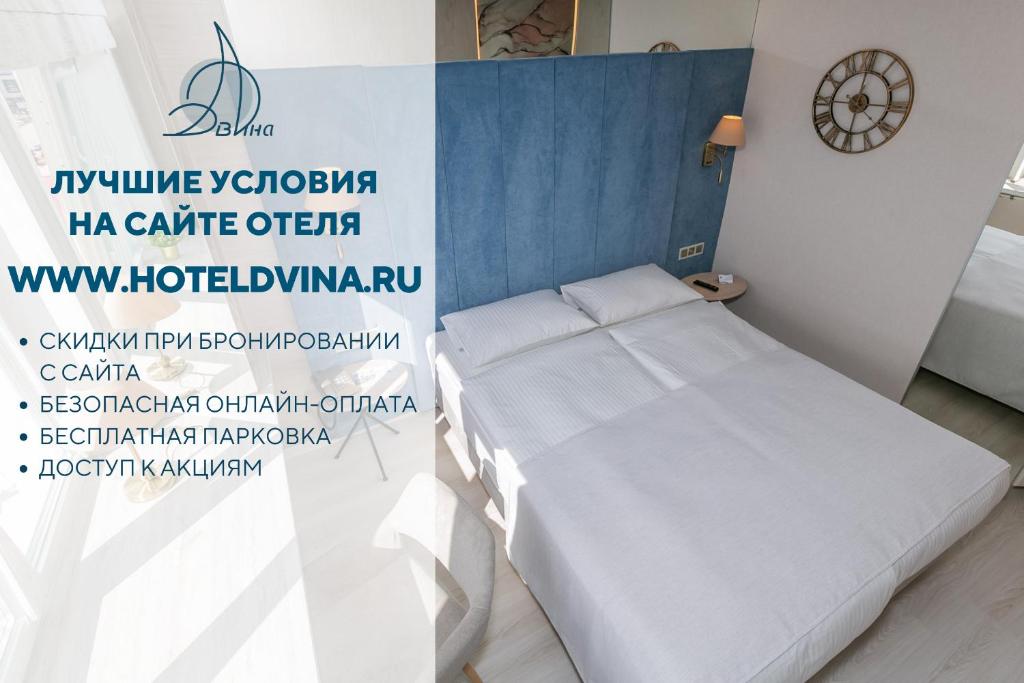 Cama en habitación con reloj en la pared en Dvina Hotel, en Arkhangelsk