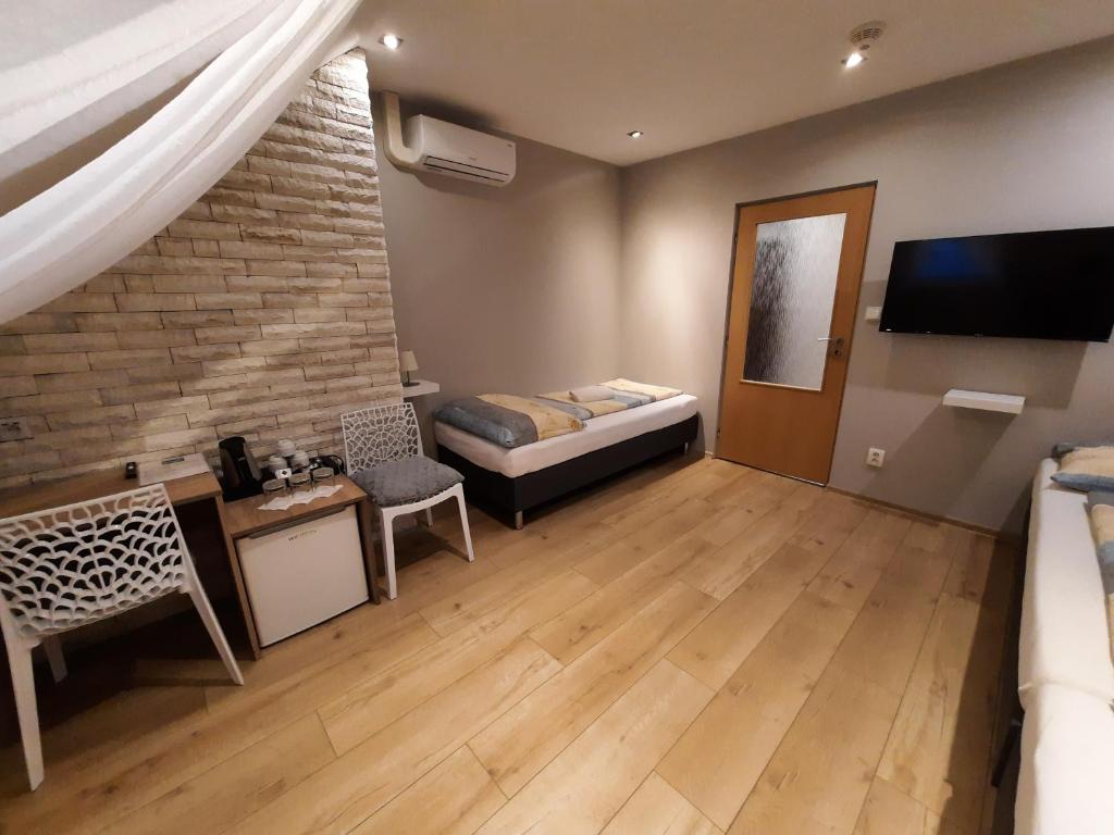 salon z łóżkiem i telewizorem w obiekcie Hotel Boršičanka w Hawierzowie