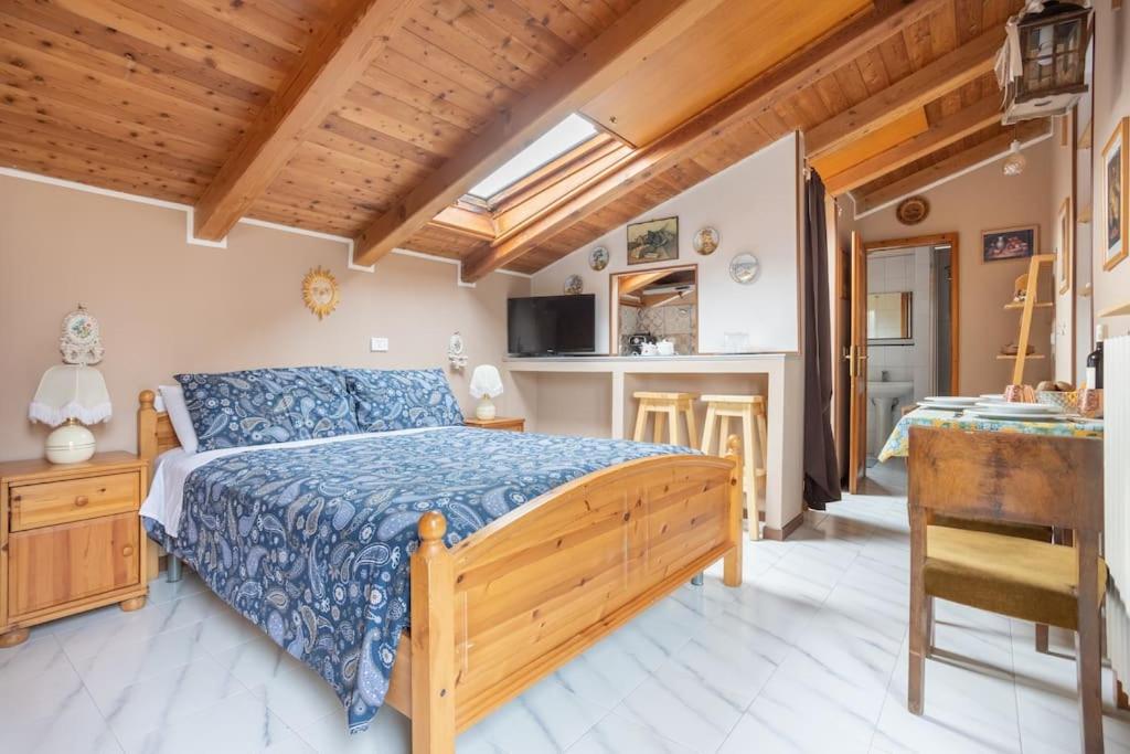 a bedroom with a large bed and a kitchen at Lo chalet di Giulia - Romantic terrace in Bologna