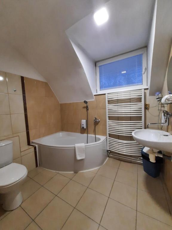 łazienka z wanną, toaletą i umywalką w obiekcie Hotel Boršičanka w Hawierzowie