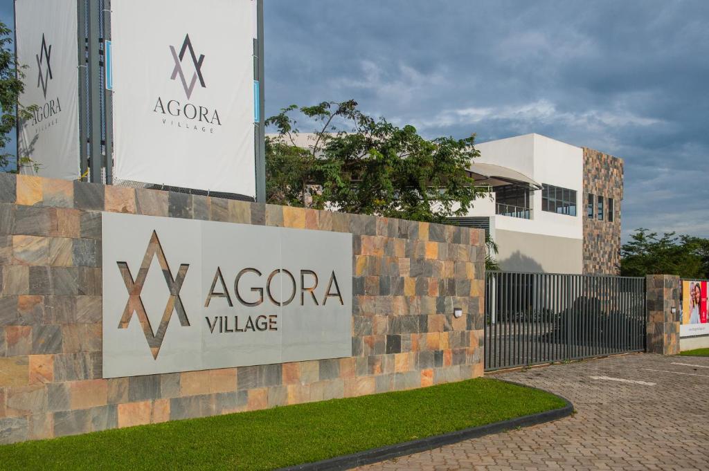un panneau indiquant la villa azaoco en face d'un bâtiment dans l'établissement Agora Apartments, à Lusaka