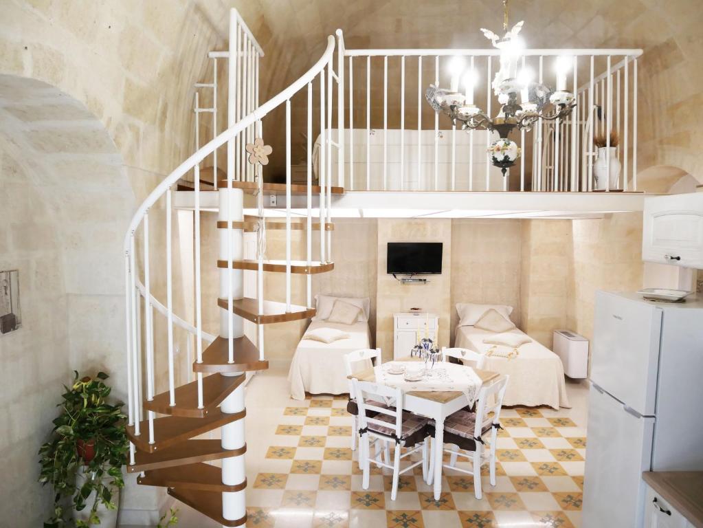 a living room with a spiral staircase and a table at Casa Sant'Agata in Laterza