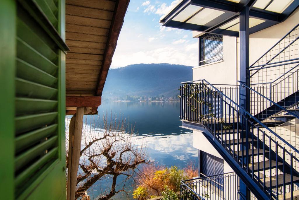 uma vista para um lago a partir da varanda de uma casa em Mansarda Verde by Quokka 360 - cosy attic apartment with lake view em Ponte Tresa