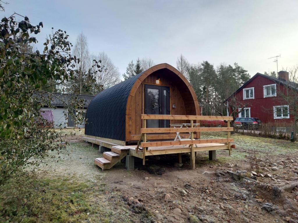 eine Holzhütte mit einer Bank und einem Gebäude in der Unterkunft Hobbit Hut in Hallstahammar
