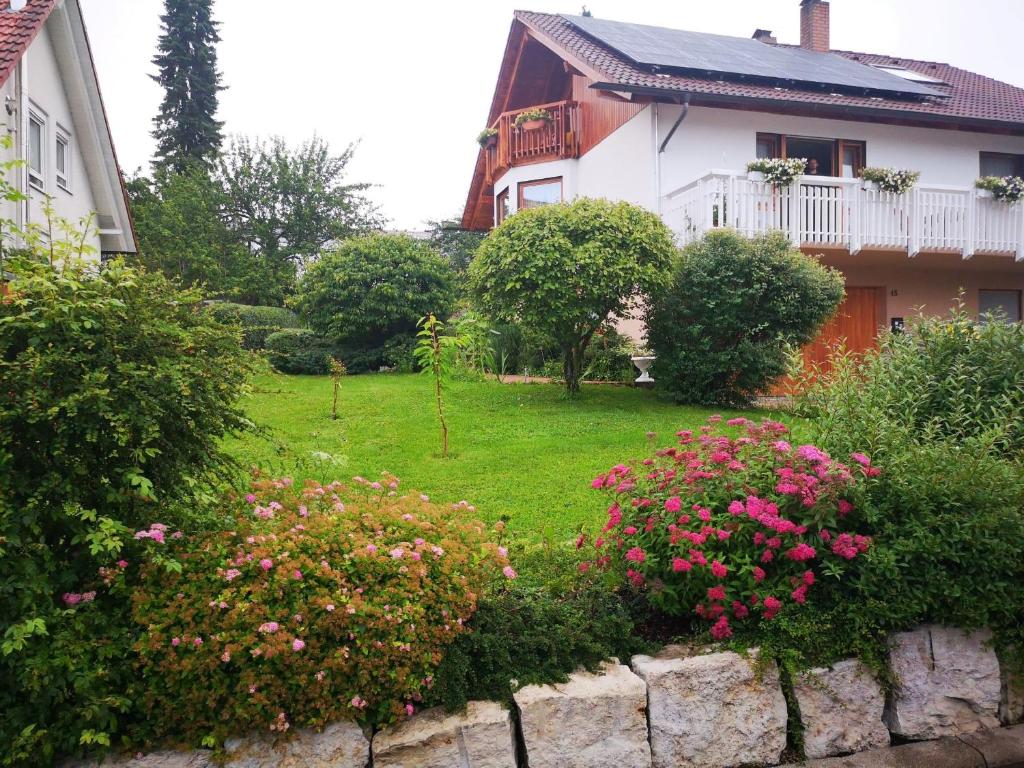 巴特烏拉赫的住宿－Biosphärenzimmer Bad Urach，一座花园,在房子前方种有粉红色的花朵