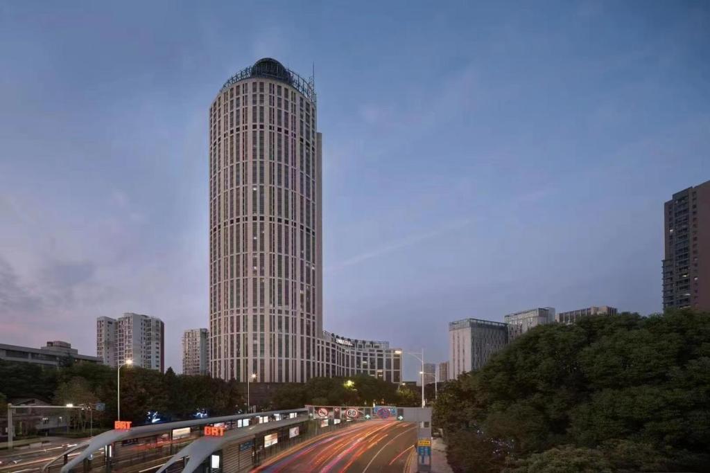 ein hohes Gebäude mitten in einer Stadt in der Unterkunft Changzhou Yuanzhou Hotel in Changzhou