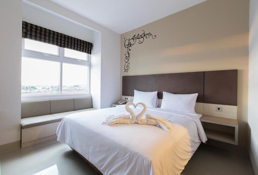 Rúm í herbergi á Sparks Odeon Sukabumi, ARTOTEL Curated