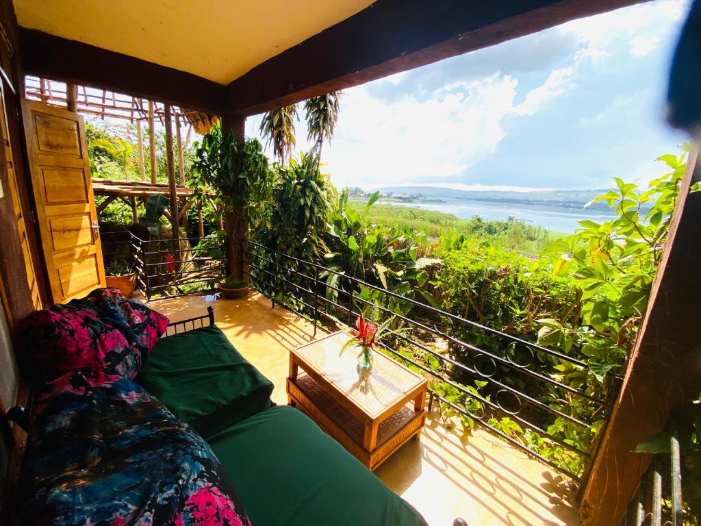 a balcony with a couch and a view of the ocean at HomeOnTheNile Lake view double in Jinja