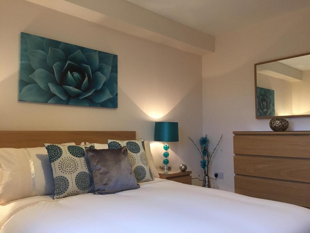 a bedroom with a bed and a painting on the wall at AB11 Apartments - Portland Street in Aberdeen